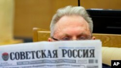 На фото від Держдуми Росії: депутат читає газету "Радянська Росія" перед засіданням російського парламенту, Москва, Росія, 13 липня 2023 р. The State Duma, the Lower House of the Russian Parliament via AP
