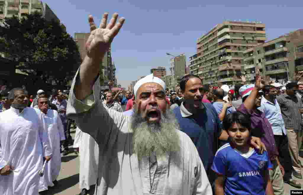 Para pendukung Ikhwanul Muslimin dan presiden terguling Mohamed Morsi meneriakkan slogan menentang militer dan Menteri Dalam Negeri Mesir sambil memberikan simbol "Rabaa" di Kairo, 23 Agustus 2013.