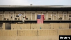 FILE - A U.S. flag hangs on a housing unit inside of Bagram Airfield in the Parwan province of Afghanistan, Jan. 2, 2015. According to numbers provided late last year by the outgoing Obama administration, the U.S. is maintaining approximately 8,400 troops in Afghanistan.