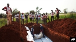 Pare pekerja Palang Merah Afrika Tengah mengubur 13 jenasah korban kekerasan dalam kuburan masal di Bangui, Republik afrika Tengah (5/1/2014). 