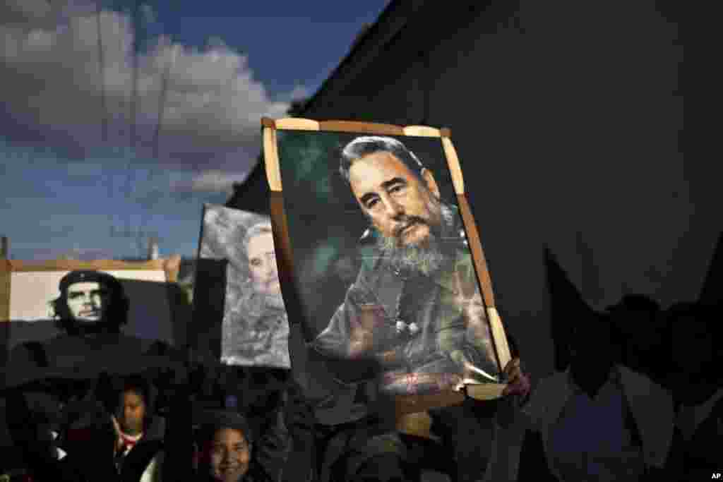 Anak-anak membawa gambar berpigura dari Fidel Castro dan Che Guevara dalam pawai karavan untuk memperingati 56 tahun pesta jalanan yang menyambut kemenangan Castro dan tentara pemberontaknya, di Regla, Kuba, 8 Januari 2015. Castro dan pasukannya tiba di Havana dengan karavan pada minggu pertama Januari 1959, setelah menggulingkan diktator Fulgencio Batista. (AP/Ramon Espinosa)