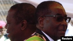 Zimbabwean President Robert Mugabe (R) and Prime Minister Morgan Tsvangirai arrive at a rally marking Zimbabwe's 31st independence anniversary celebrations in Harare, Zimbabwe, April 18, 2011. 