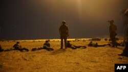 In this photo released by the U.S. Army on March 9, 2017, U.S. Army Special Forces soldiers observe as Nigerien armed forces service members fire their weapons with the assistance of illumination rounds during Exercise Flintlock 2017 in Diffa, Niger. 