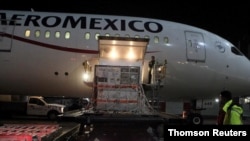 Trabajadores descargan en el Aeropuerto Internacional Benito Juárez, en la Ciudad de México, el segundo cargamento de la sustancia activa utilizada para elaborar la vacuna AstraZeneca el 11 de febrero del 2021. 