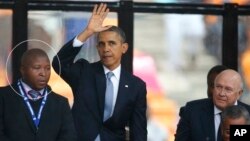 El intérprete sudafricano Thamsanqa Janjie (círculo) aparece confundido junto al presidente Barack Obama, en el homenaje a Nelson Mandela.