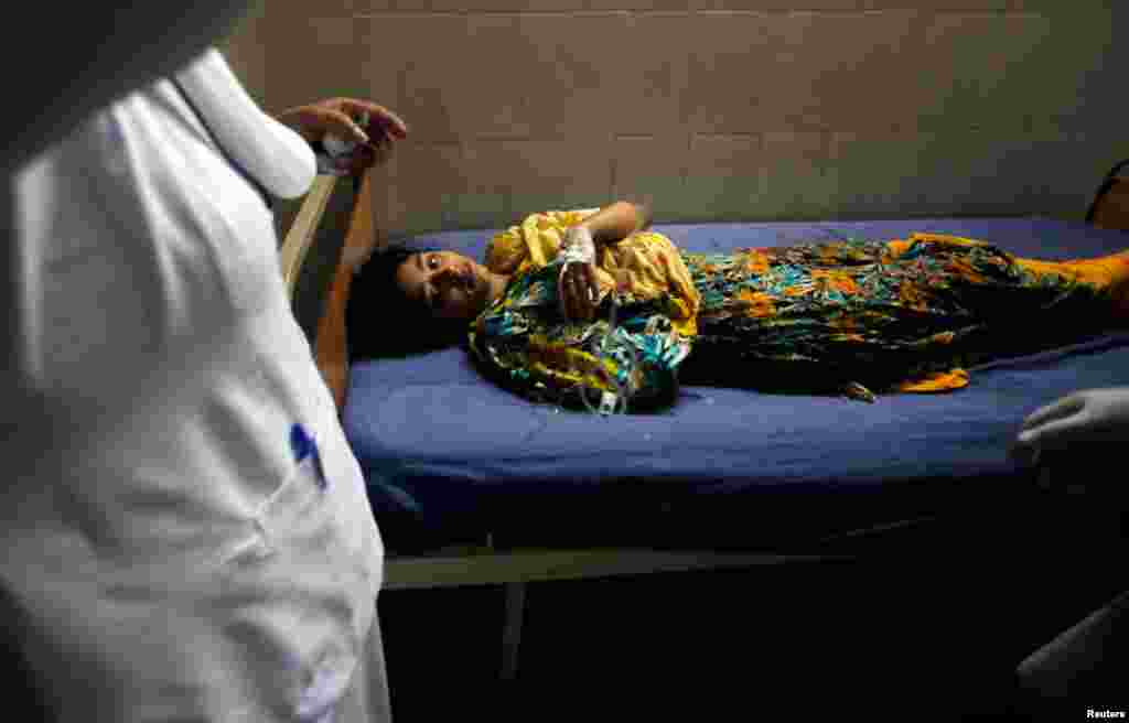 A girl who was injured in the bomb blast waits to receive treatment at a hospital in Peshawar, April 29, 2013.