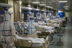 Medical workers in protective suits attend to novel coronavirus patients at the intensive care unit (ICU) of a designated hospital in Wuhan, Hubei province, China, Feb. 6, 2020.