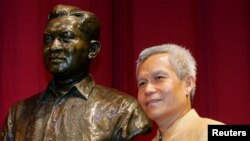 Sombath Somphone, aktivis sosial Laos, penerima penghargaan Ramon Magsaysay untuk Kepemimpinan Komunitas tahun 2005, berpose bersama patung mendiang presiden Filipina di Pusat Kebudayaan Filipina di Manila (Foto: dok). Somphone terakhir terlihat di ibukota Vientiane, saat kendaraannya dihentikan oleh pihak berwenang di luar sebuah kantor polisi, Sabtu (15/12). Pemerintah Laos membantah ikut bertanggung jawab atas hilangnya Somphone.