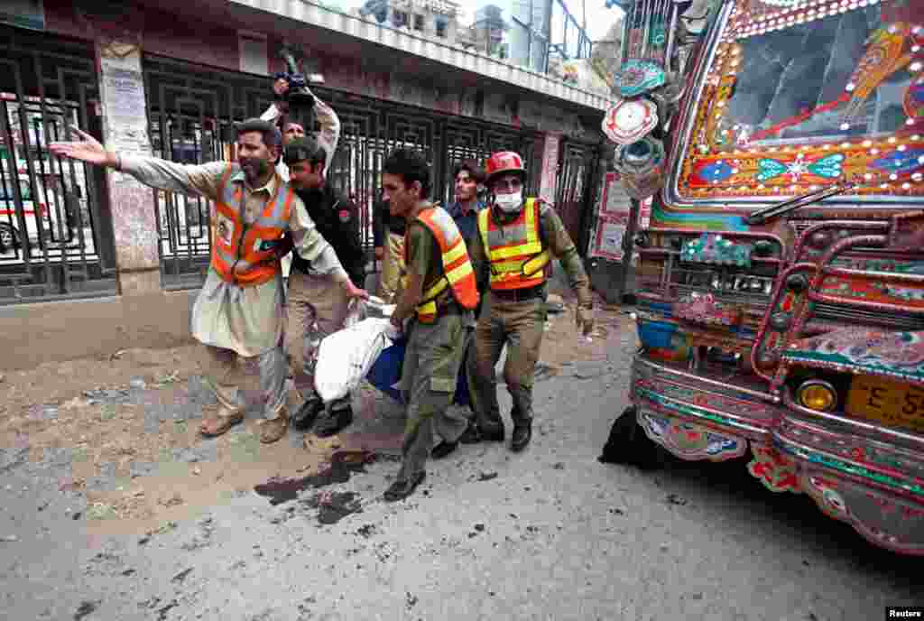 Rescue workers carry a dead body away from the site of a blast at University Road in Peshawar, Pakistan, April 29, 2013.