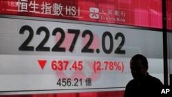 Un homme passe devant un écran de l'indice Hang Seng devant une banque à Hong Kong, le 9 novembre 2016.