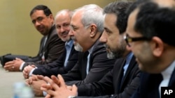 Menteri Luar Negeri Iran Javad Zarif (tengah) dalam pembicaraan mengenai program nuklir Iran di Jenewa (22/11). (AP/Fabrice Coffrini)