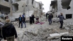 Des résidents inspectent un site touché par trois frappes aériennes consécutives menées par les forces aériennes russes, dans la zone contrôlée par les rebelles de la ville Maaret al-Numan dans la province de Idlib, en Syrie le 12 janvier 2016. (REUTERS/Khalil Ashawi)