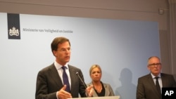 Perdana Menteri Belanda Mark Rutte, kiri, dalam konferensi pers menjelaskan pemerintah Belanda menunda pengiriman tentara bersenjata untuk menjaga lokasi jatuhnya pesawat MH17.